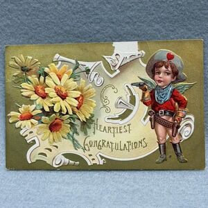 Winged Cupid Cowboy Heartiest Congratulations Flowers Embossed 1900s POSTCARD